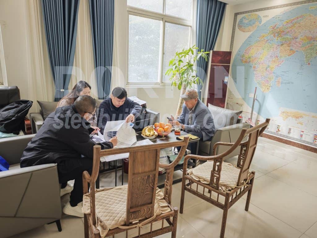 Business meeting in an office with a large world map and natural light from windows.