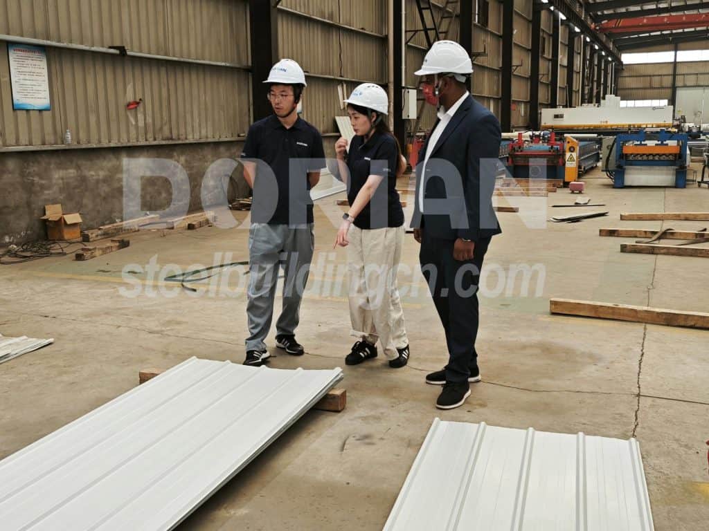 Ethiopian clients inspecting steel building components at Dorian factory.