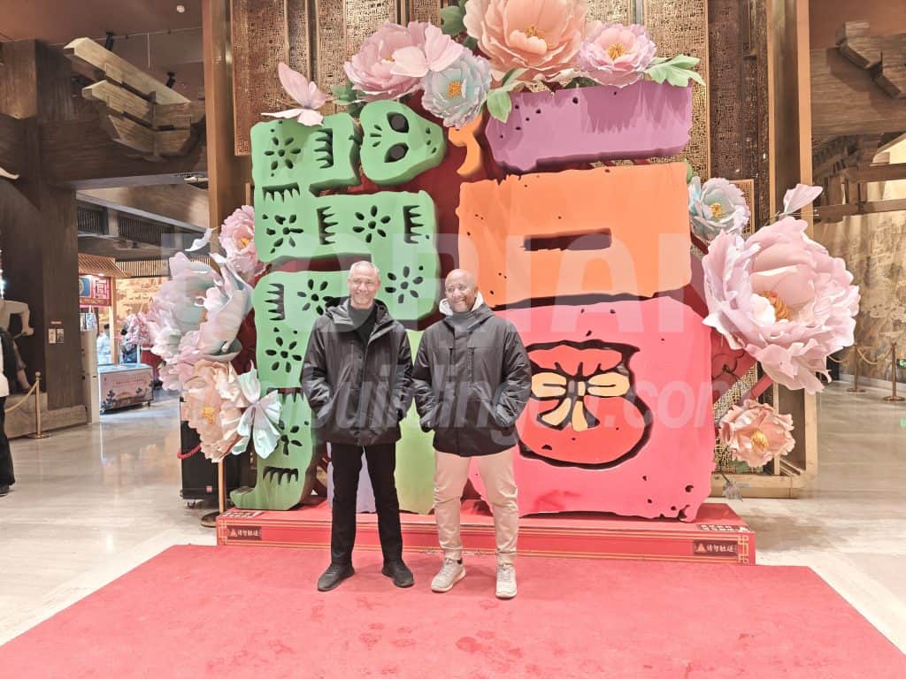Vibrant colorful art display with flowers and two people in shopping mall.
