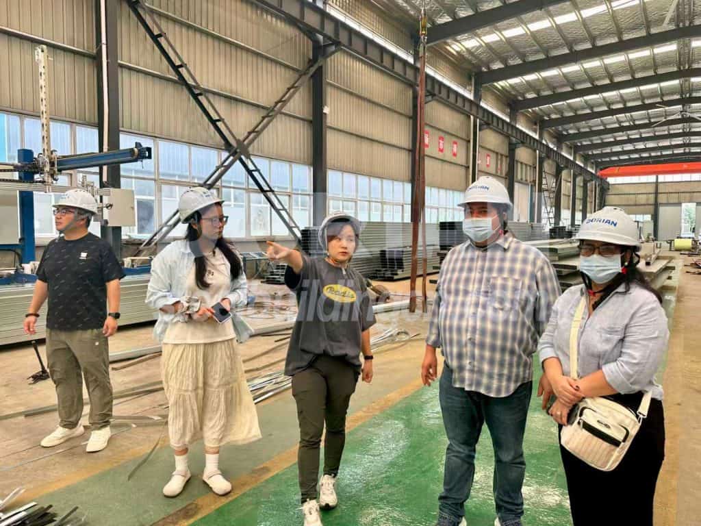 Steel building inspection team discussing project details inside a large industrial warehouse.