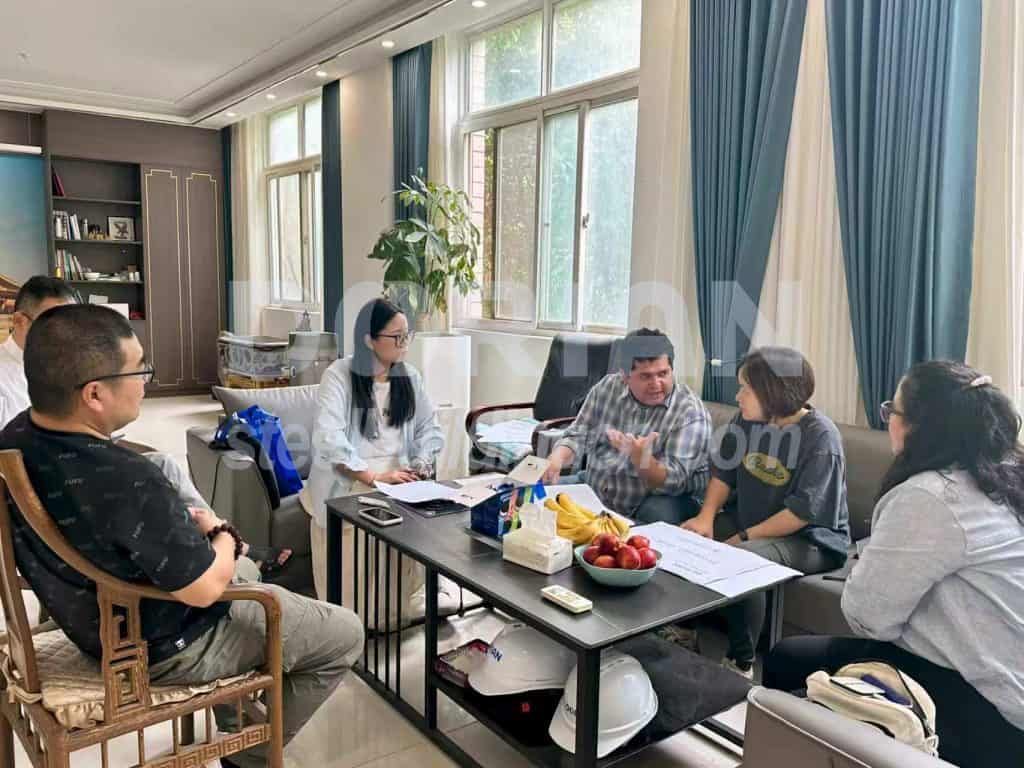Office meeting with five professionals collaborating around a table.