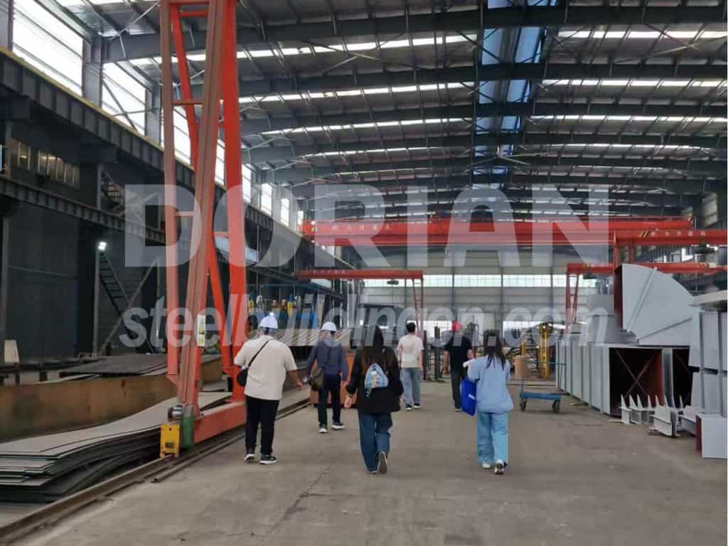 Steel building structure with visitors touring the facility.