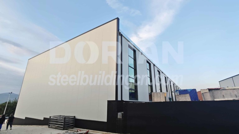 A modern steel workshop with large windows, showcasing durable construction and sleek design. Modern Steel Structure Workshop Building